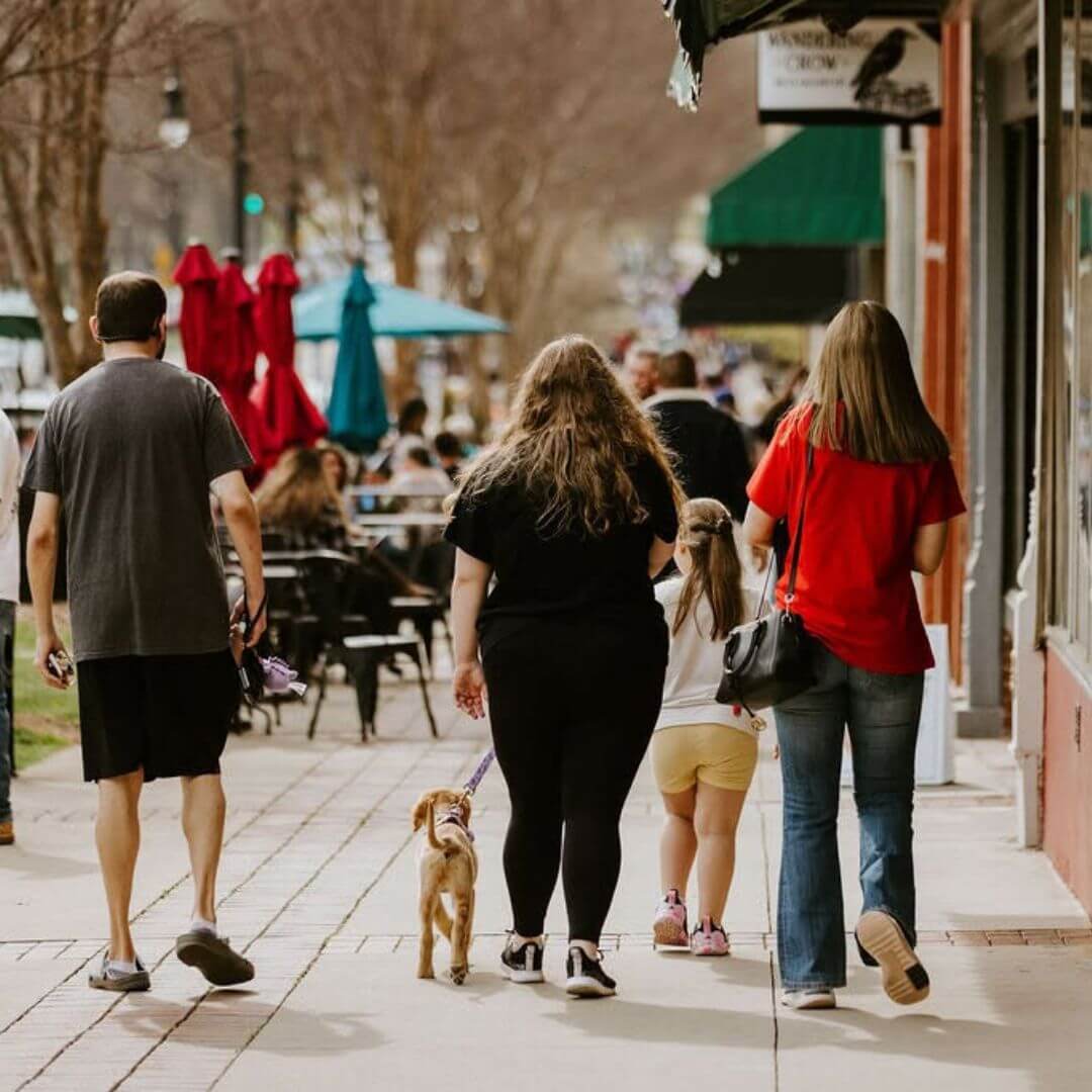 Family walking with a dog through downtown Statesville, North Carolina